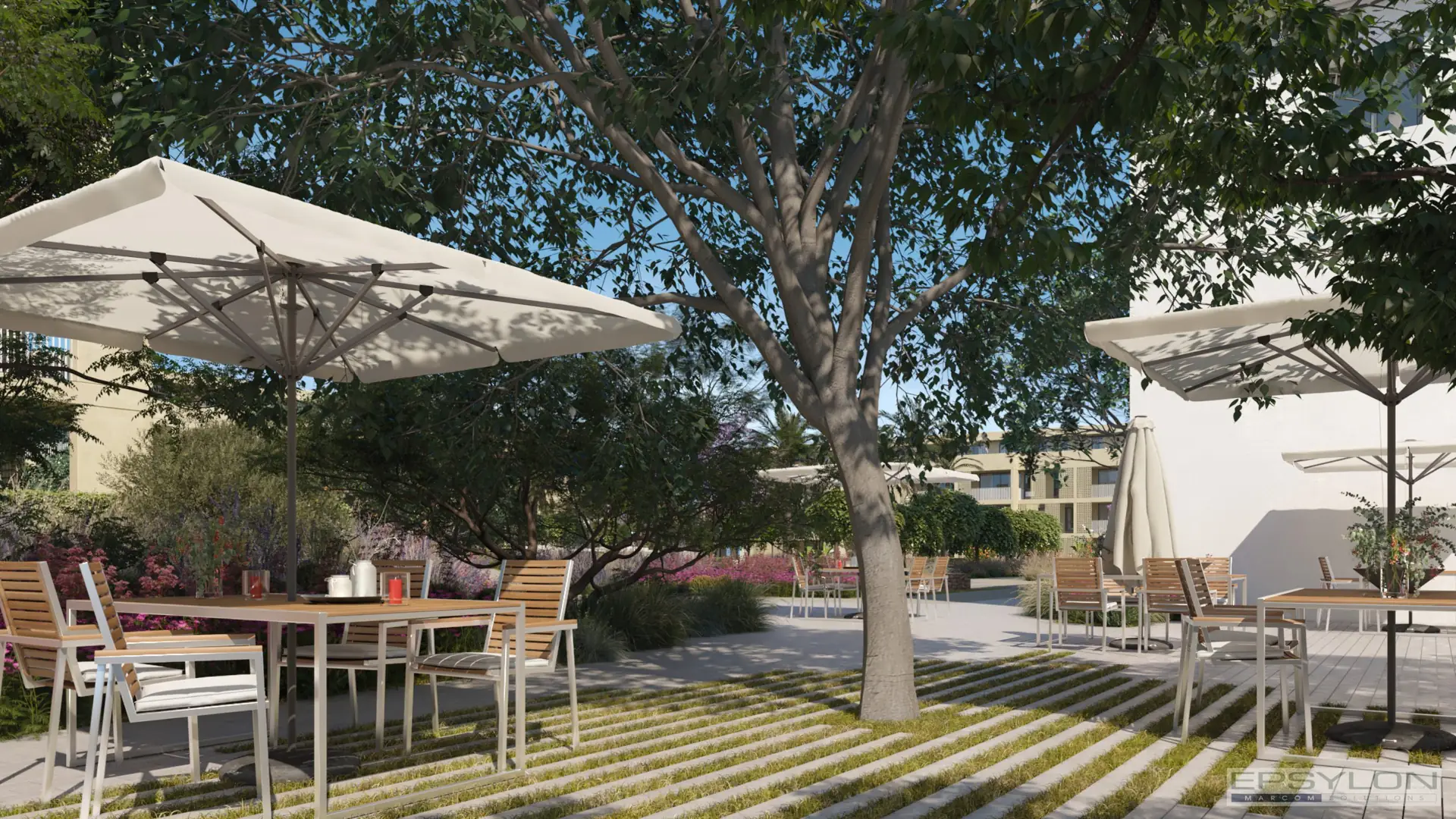 Área estancial exterior en urbanización con mobiliario urbano, mesas y zonas de sombra bajo arbolado